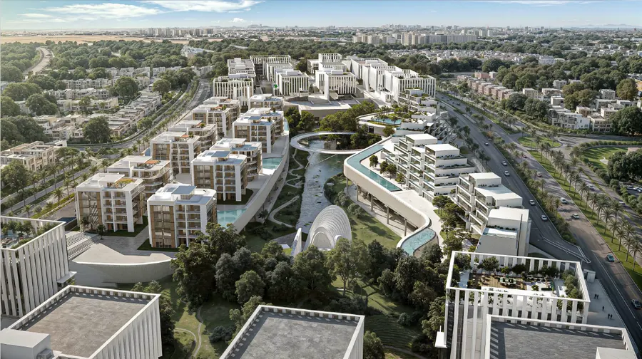 Daytime aerial of W55 New Cairo: terraced residential and hotel buildings, the circular bridge and the green valley